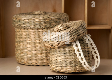 Two wattled baskets with lace closeup isolated on wooden background Stock Photo