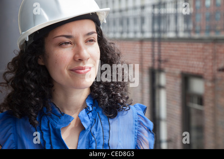 Smiling Hispanic businesswoman wearing hard-hat Stock Photo