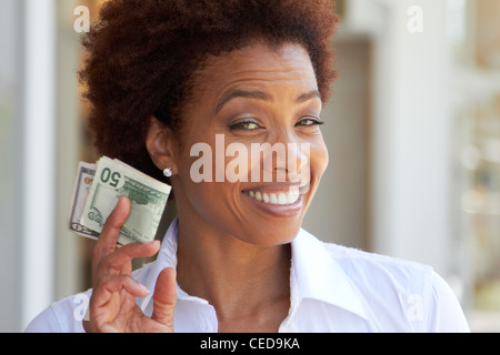 African American woman holding 50 dollar bill Stock Photo
