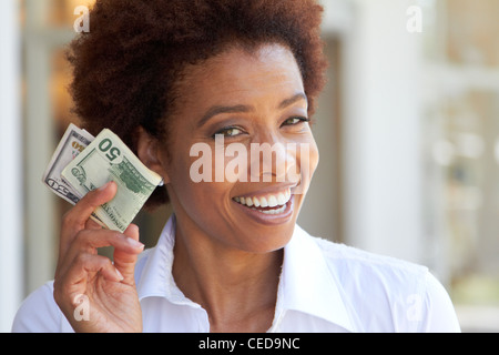 African American woman holding 50 dollar bill Stock Photo