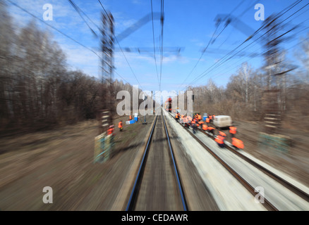 View on railway with maintenance crew from moving train, motion blur Stock Photo