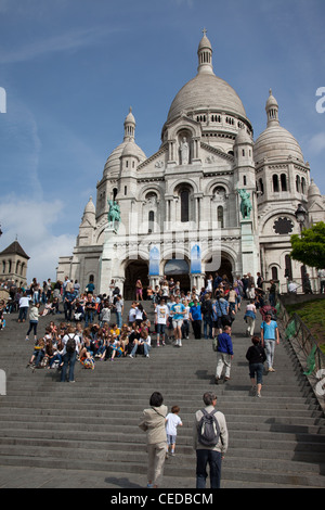 Tourists walking up and sitting on the steps leading to Basilique du Sacre Coeur in Montmartre Paris France Stock Photo