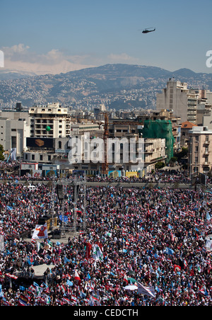 Up to a million people fill Martyrs Square in Beirut, Lebanon. Snow-capped mountains seen beyond city-centre towers Stock Photo