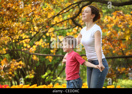 Mother with son to keep for hands in garden in spring Stock Photo