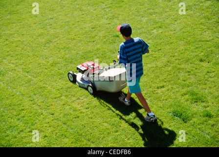 Teenage Boy Mowing a Well Kept Suburban Lawn, United States  1990s Stock Photo