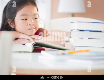 Bored asian school girl sitting at desk in classroom Stock Photo - Alamy
