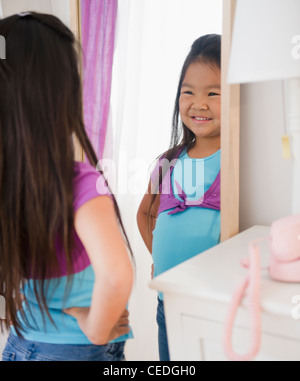 Girl looking at reflection in mirror decorated with heart shape Stock ...