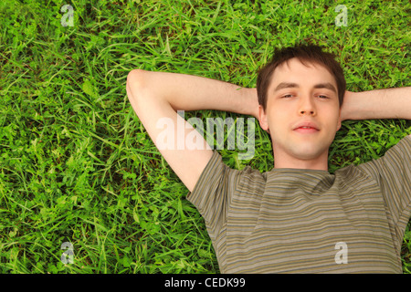 young man lies on grass Stock Photo