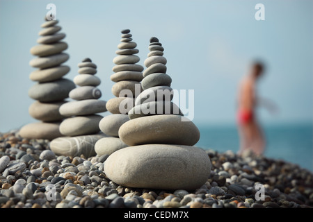 stone stacks on pebble beach and boy out of focus