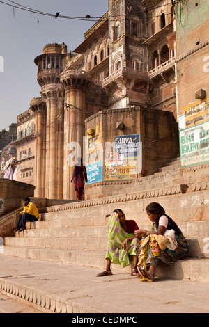 India, Uttar Pradesh, Varanasi, Munshi Ghat, two women sat on ghats in early morning sunshine Stock Photo