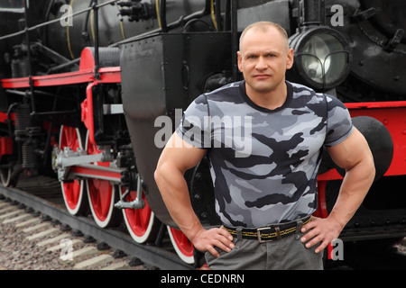 strong man against locomotive Stock Photo