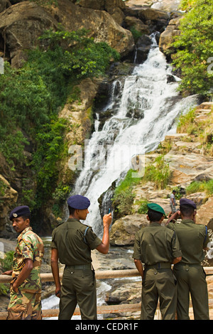 Sri Lankan Army soldiers taking photos at Rawana (Ravana) Falls, a popular sight by the highway in Ella Gap; Ella, Sri Lanka Stock Photo