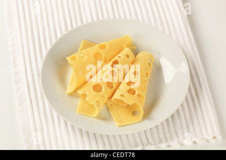 Thin slices of Swiss cheese on a plate Stock Photo