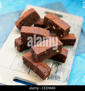 Triple chocolate crunch bars stacked on a wooden board, close-up Stock Photo
