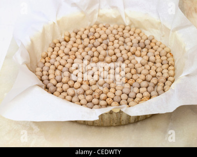Ceramic baking beans in tart tin Stock Photo