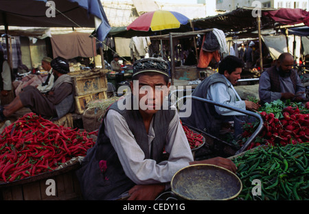 A teenage boy selling vegetables on a stall in the bazaar in Mazar-i-Sharif Stock Photo