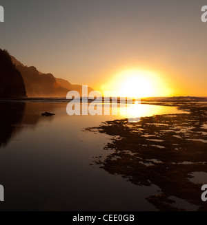 Reflections of setting sun over Na Pali coast by Ke'e beach in Kauai at sunset Stock Photo