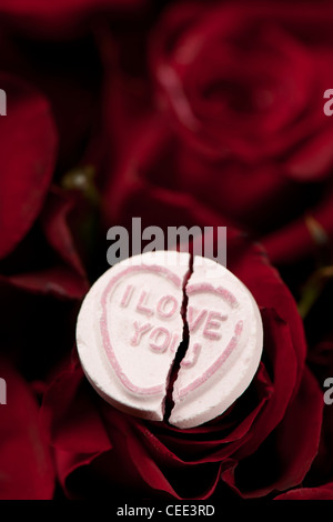 Broken I Love You love Heart sweet sitting on Red Roses Stock Photo