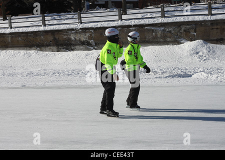 Two skaters in reflective coats and white helmets Stock Photo