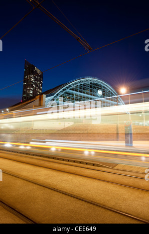 Light trails of a tram rushing past imprint themselves on a shot of Manchester Central GMex Centre. Stock Photo