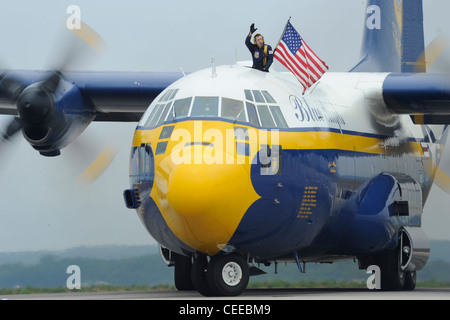 Marine Gunnery Sgt. Joe Alley, a C-130 navigator assigned to the U.S. Navy flight demonstration squadron, the Blue Angels, waves to the crowd after Fat Albert, the Blue AngelsÕ C-130 Hercules, lands while performing at the Rhode Island National Guard Open House Air Show. The Blue Angels performed in Rhode Island during the 2011 show season and in celebration of the Centennial of Naval Aviation. Stock Photo
