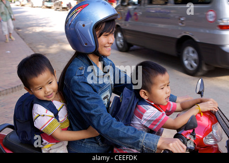 A mother travels with her two sons on a moped on Sakkaline Road Stock Photo