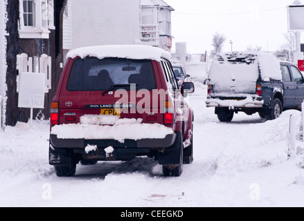 Cars Vehicles Car Vehicle Driving On THe Road Street In the Heavy Snow UK Stock Photo