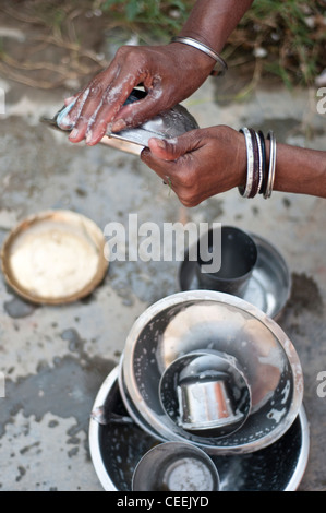 Widow cleaning dishes, Ma Dham Ashram, run by NGO Guild of Service, Vrindavan, Uttar Pradesh, India Stock Photo
