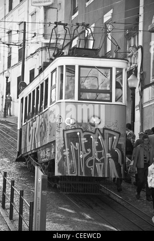 A Portuguese elevator tram stops to let off passengers and let new ones on. Lisbon, Portugal. Stock Photo
