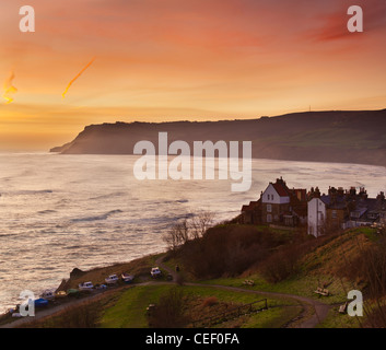 Sunrise over Robin Hoods Bay and Baytown with The Old Peak Cliff at Ravenscar seen in the distance. North Yorkshire, UK Stock Photo