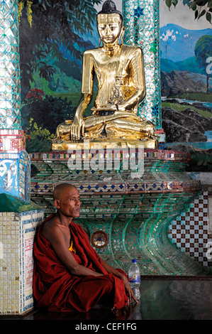 red robed buddhist monk meditate meditating pray praying Shwedagon Pagoda Myanmar Burma Yangon Rangoon historic temple holy site Stock Photo