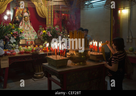 dh Man Mo Temple SHEUNG WAN HONG KONG Woman joss stick urns chinese shrine deity daoism altar burner sticks of incense