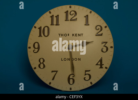 An old-fashioned analogue clock on a blue background reads 2.30 Stock Photo