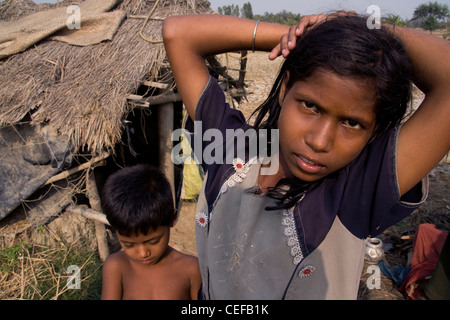 Children have been forced to relocate due to sea level rise. They are pictured in front of their new home. Stock Photo