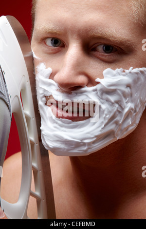 Handsome guy shaving with a skate blade Stock Photo