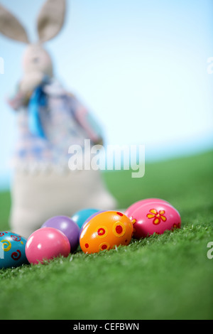 Tilt up shot of Easter eggs and a toy bunny in the background Stock Photo