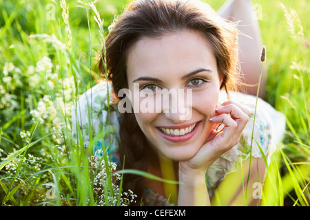 Smiling woman laying in tall grass Stock Photo