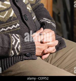 Older man sitting with hands folded Stock Photo