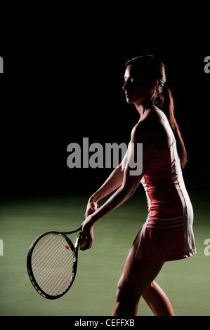 Woman playing tennis indoors Stock Photo