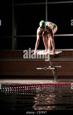 Swimmer poised to dive into pool Stock Photo