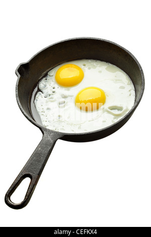 Fried eggs on castiron pan isolated over white background Stock Photo