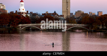 A lone rower on the Charles River with parts of Harvard University with full Fall foliage in the background. Stock Photo