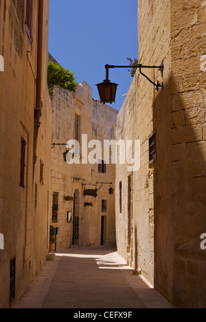 A narrow street with wrought iron lamps in Mdina (a.k.a. Citta Vecchia - Old City) Stock Photo