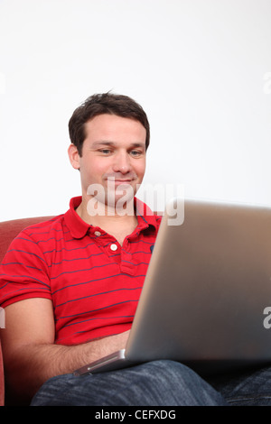 Profile of a smiling man using a laptop.