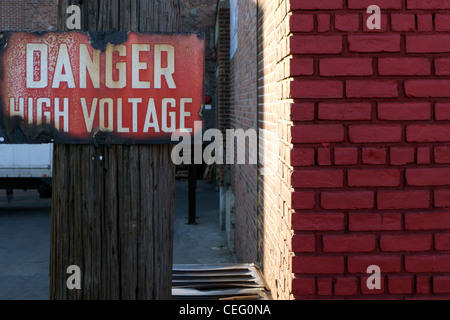 Rusty old 'Danger: High Voltage' sign on a utility pole, Brooklyn, New York Stock Photo