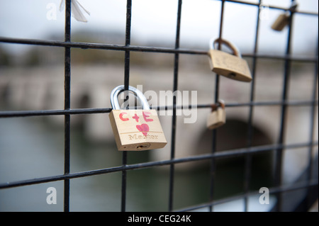 locks as symbols of love chained to a bridge in Paris, France Stock Photo