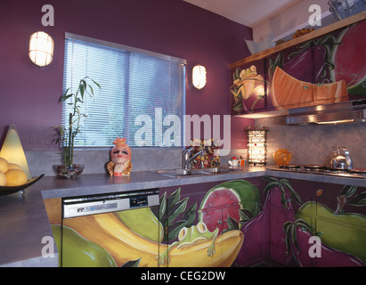 Trompe-l'oeil fruit painted on dishwasher and cupboard in retro purple Californian kitchen Stock Photo