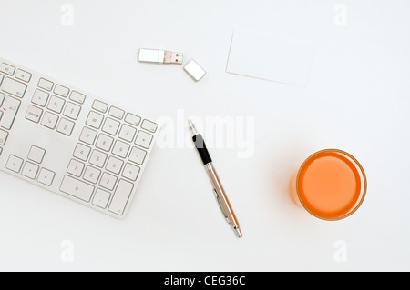 Office desktop, a keyboard, pen and a usb flash drive. Stock Photo