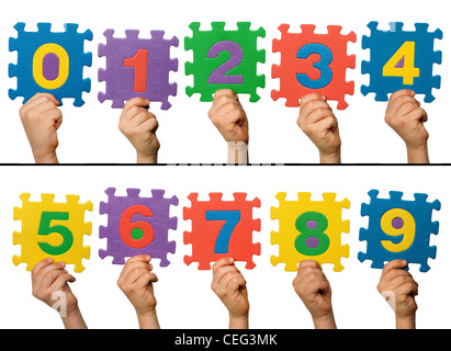 Children hands holding numbers. White isolated multicolor numbers. Stock Photo