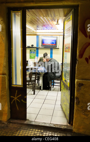 Men sitting in a betting office, Athens, Greece, Europe Stock Photo